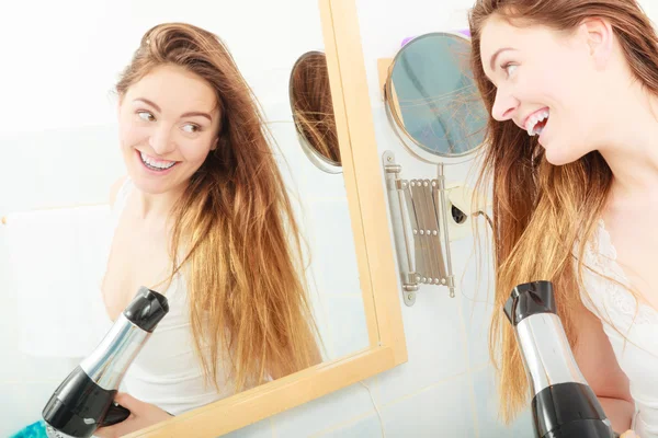 Langhaarige Frau trocknet Haare im Badezimmer — Stockfoto