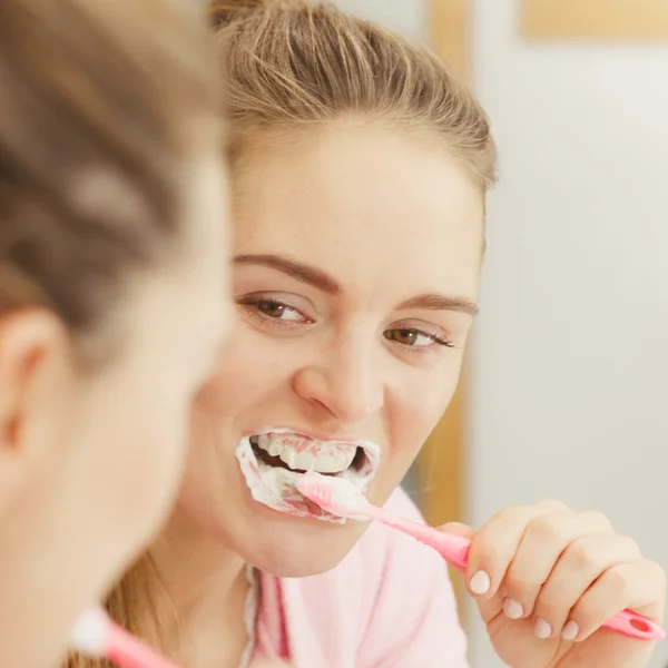 Mujer cepillarse los dientes de limpieza en el baño —  Fotos de Stock