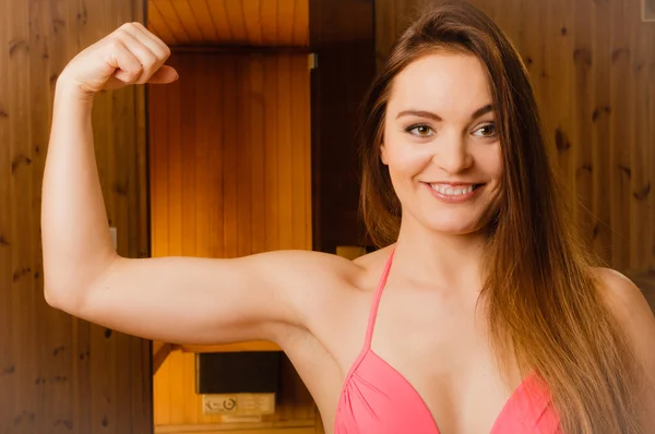 Žena relaxaci v sauně, předváděl svaly. — Stock fotografie
