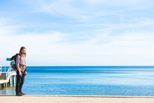 Man hiker with backpack tramping by seaside — Stock Photo, Image