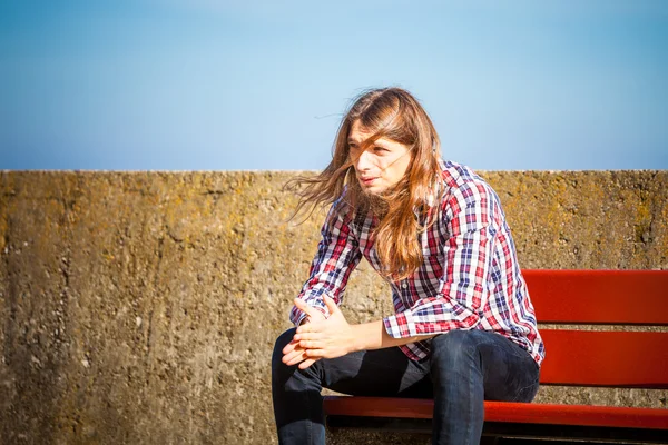 Μακριά μαλλιά άνθρωπος κάθεται σε παγκάκι εξωτερική — Φωτογραφία Αρχείου