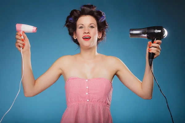 Menina com encrespadores no cabelo detém secadores de cabelo — Fotografia de Stock