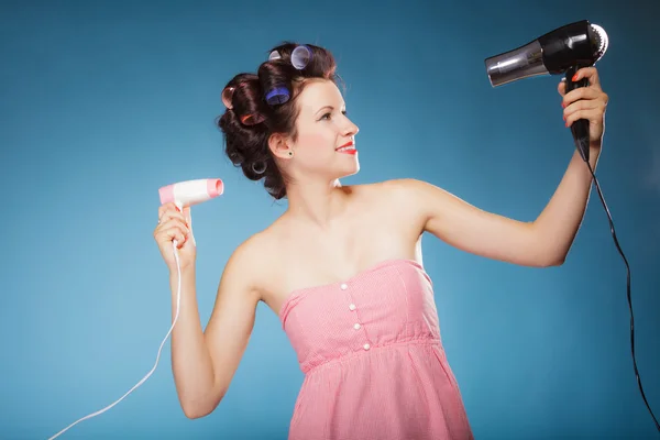 Menina com encrespadores no cabelo detém secadores de cabelo — Fotografia de Stock