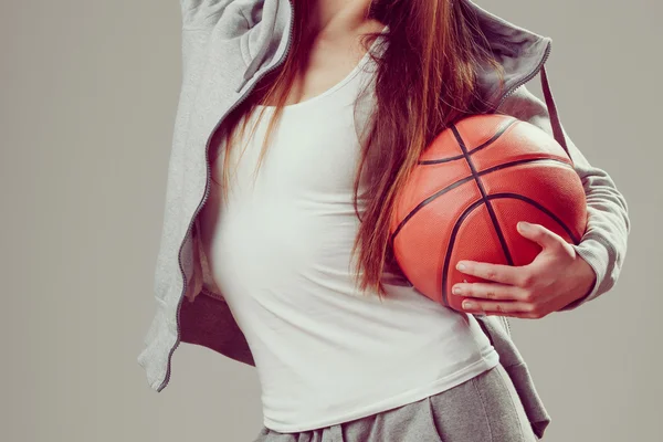 Sporty teen girl in hood holding basketball. — Stock Photo, Image