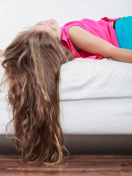 Little girl kid with long hair upside down on sofa — Stock Photo, Image