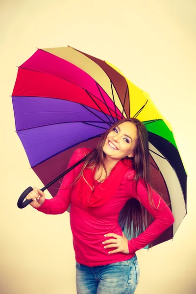 Woman standing under multicolored umbrella — Stock Photo, Image