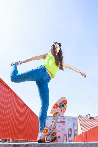 Девушка-фигуристка катается на скейтборде по улице. — стоковое фото