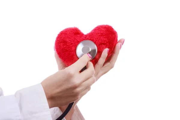 Doctor with stethoscope examining red heart. — Stock Photo, Image