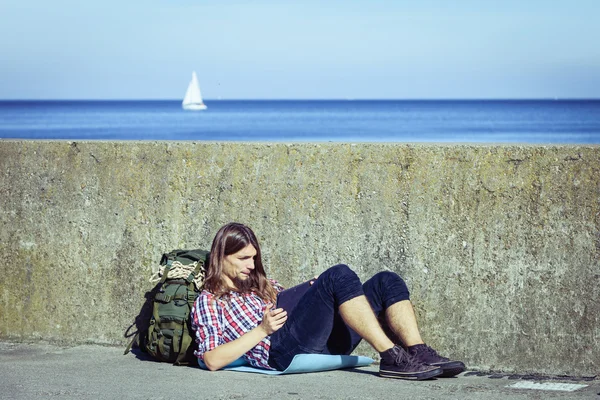 Homme sac à dos touristique assis avec tablette extérieure — Photo