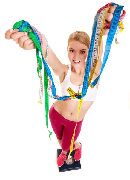 Happy woman with tape measures on weighing scale. — Stock Photo, Image