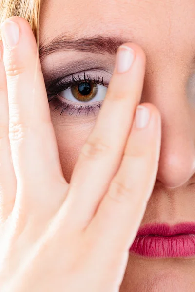 Kvinna täcka ansikte ser genom fingrarna. — Stockfoto