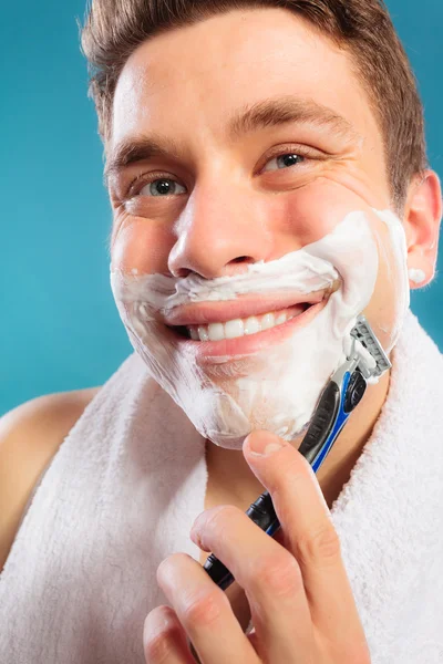 Uomo felice rasatura utilizzando rasoio con schiuma crema . — Foto Stock
