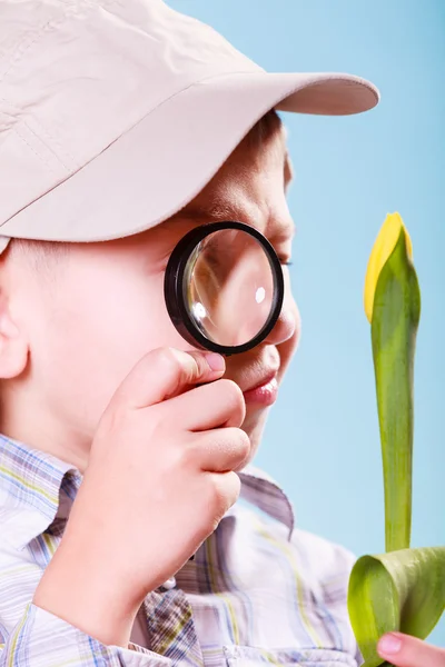 Young boy hold flower and magnifying glass. — Stock Photo, Image