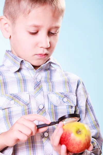 Kid examine apple with magnifying glass. — Stock Photo, Image