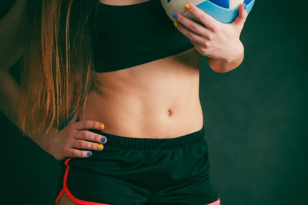 Mujer joven usar ropa deportiva y mantener la pelota . — Foto de Stock