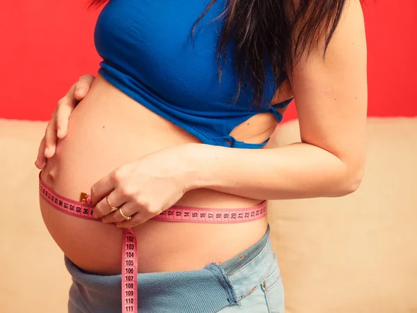 Pregnant woman measuring tummy — Stock Photo, Image