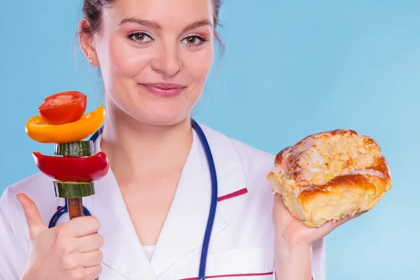 Diététiste avec pain sucré et légumes . — Photo