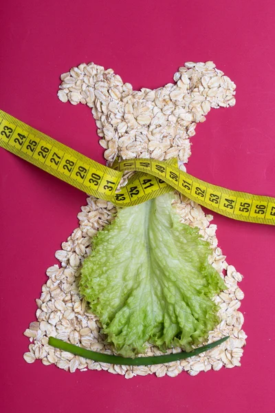 Dress shape made from oatmeal with measuring tape — Stock Photo, Image