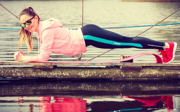 Girl training in sporty clothes on lake shore — Stock Photo, Image