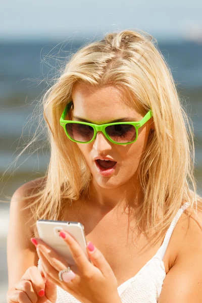 Girl on beach with phone. — Stock Photo, Image