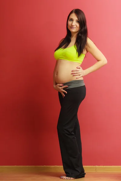 Cabello largo en forma de mujer embarazada en rojo —  Fotos de Stock