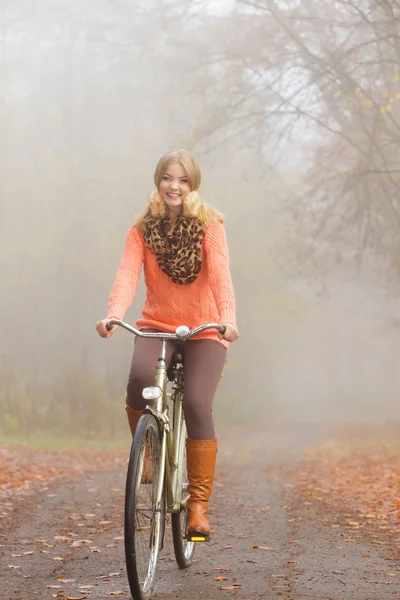 Mujer activa feliz montar en bicicleta en el parque de otoño . —  Fotos de Stock