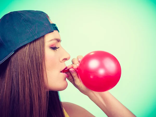 Teenager Mädchen bläst roten Luftballon. — Stockfoto