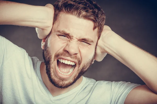 Hombre enojado que sufre de dolor de cabeza migraña dolor . —  Fotos de Stock