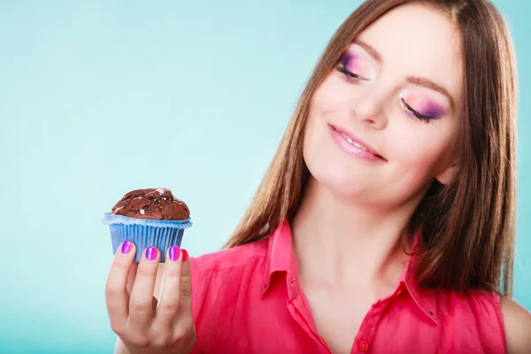 Mujer sonriente sostiene pastel de chocolate en la mano —  Fotos de Stock