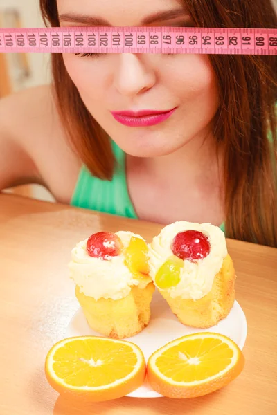 Γυναίκα με μεζούρα και κέικ. Διατροφή δίλημμα. — Φωτογραφία Αρχείου