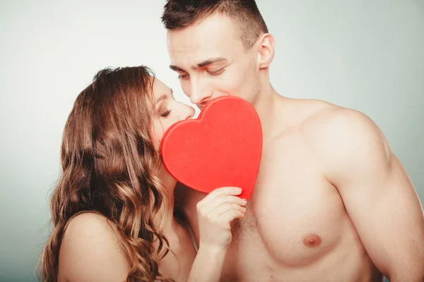 Pareja cariñosa besándose detrás del corazón rojo. Amor. . — Foto de Stock