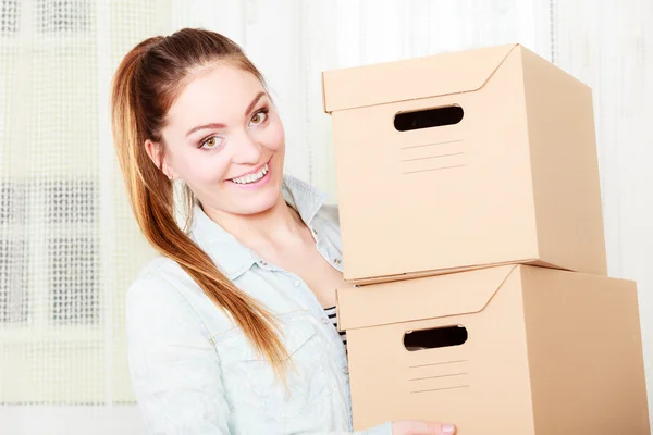 Happy woman moving into house carrying boxes. — Stock Photo, Image