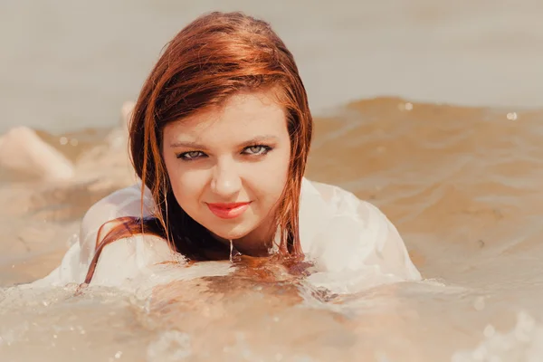 Sensuelle fille chiffon humide dans l'eau sur la côte. — Photo