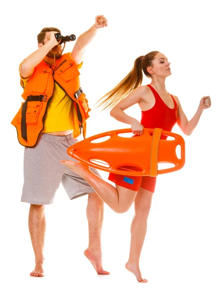 Lifeguards in life vest with rescue buoy running — Stock Photo, Image
