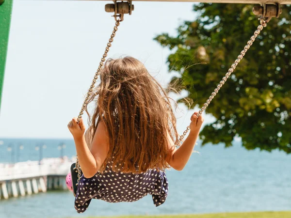 Chica balanceándose en swing-set . — Foto de Stock