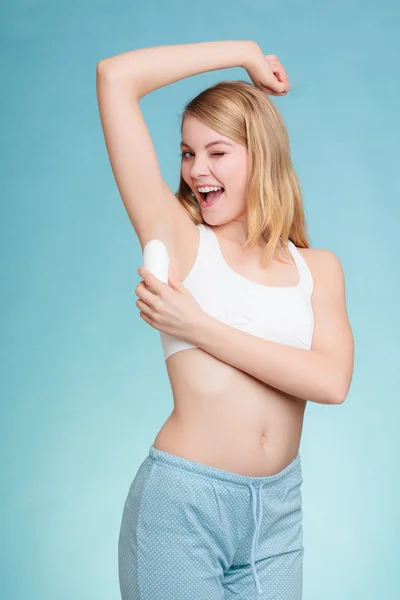 Dívka aplikuje tyčinku deodorant v podpaží. — Stock fotografie