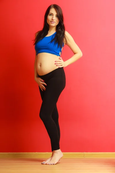 Cheveux longs ajustement femme enceinte sur rouge — Photo