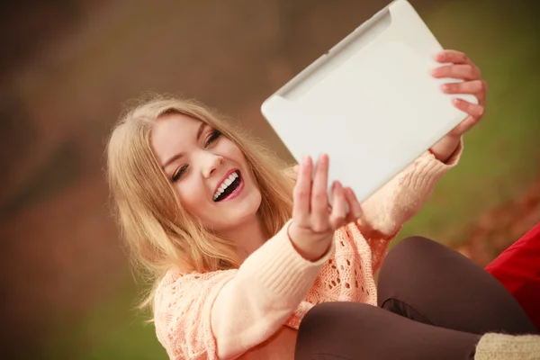 Fille assise sur un banc avec tablette . — Photo