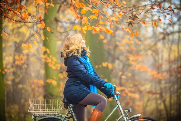 Donna attiva in bicicletta nel parco autunnale . — Foto Stock