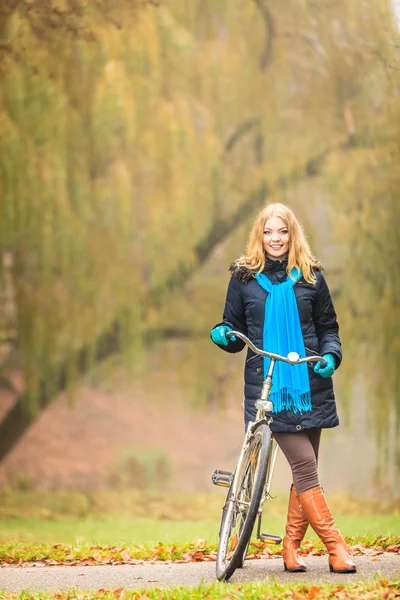 Felice donna attiva con bici nel parco autunnale . — Foto Stock