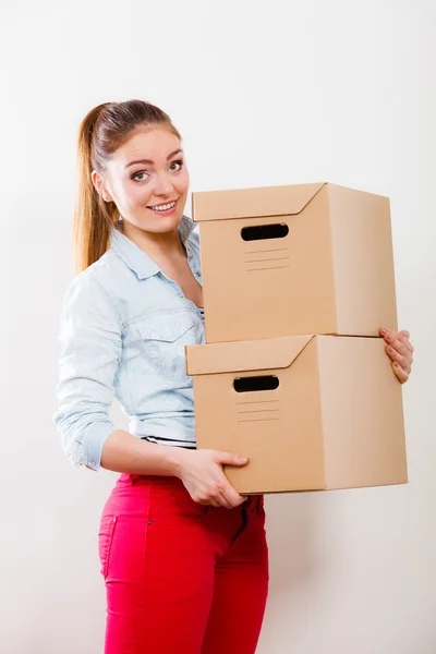 Happy woman moving into house carrying boxes. — Stock Photo, Image