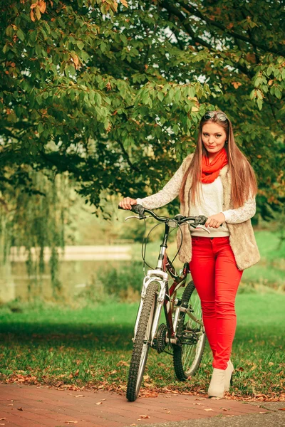 Chica relajante en el parque otoñal con bicicleta. — Foto de Stock
