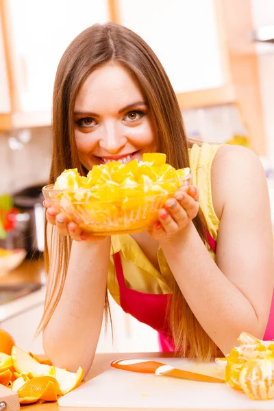 Mujer sostiene cuenco lleno de frutas de naranja en rodajas —  Fotos de Stock