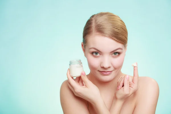 Mujer aplicando crema en su cara de piel. — Foto de Stock