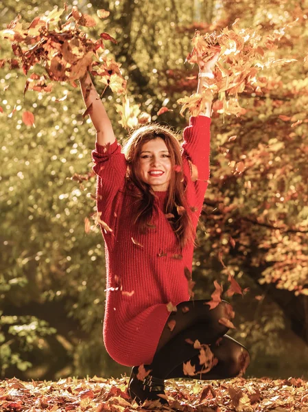 Mujer relajante en otoño parque lanzando hojas en el aire —  Fotos de Stock