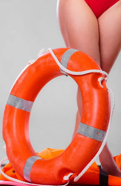 Кольцо спасательного буя и женские ноги — стоковое фото