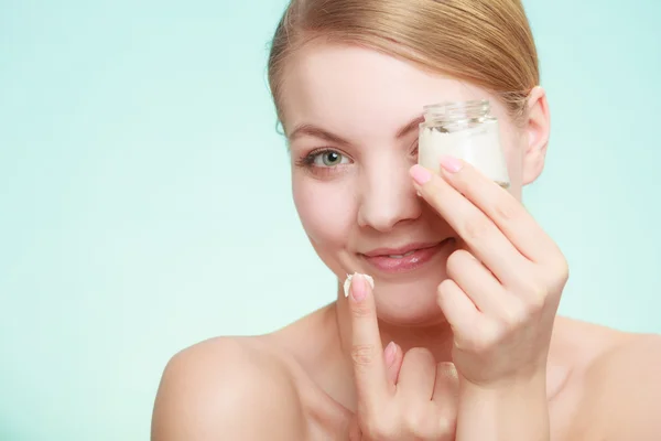 Mujer aplicando crema en su cara de piel. —  Fotos de Stock