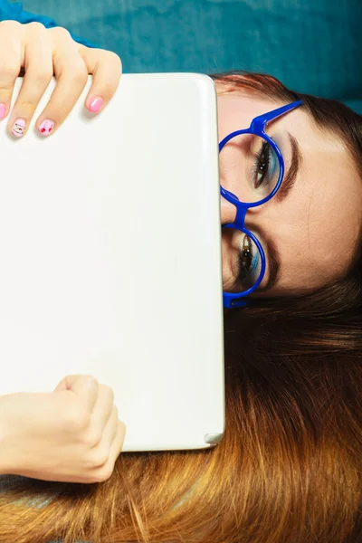 Žena s tabletem relaxační na gauč modré barvy — Stock fotografie