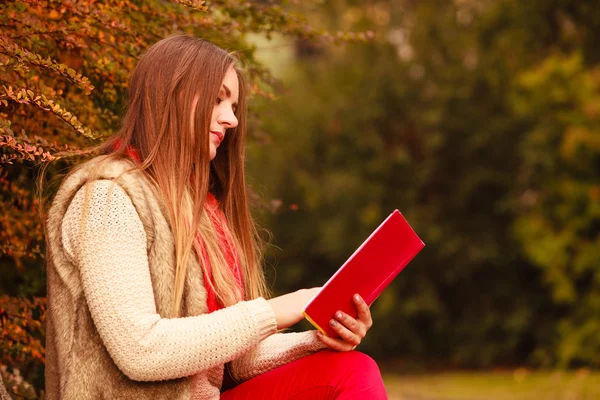 Woman relaxing in autumnal park reading book — Stock Photo, Image