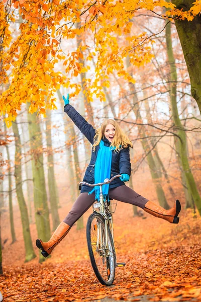 Aktywna kobieta bawiąca się na rowerze w jesiennym parku — Zdjęcie stockowe
